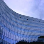 fish eye view photo of glass high story building over white cloudy sky during daytime