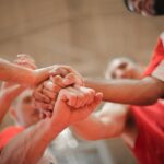 basketball team stacking hands together