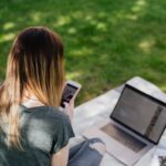 teenager surfing social media on mobile in park