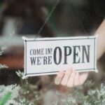 crop person showing signboard on window