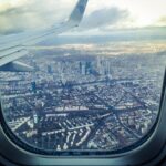 airplane windowpane showing city buildings