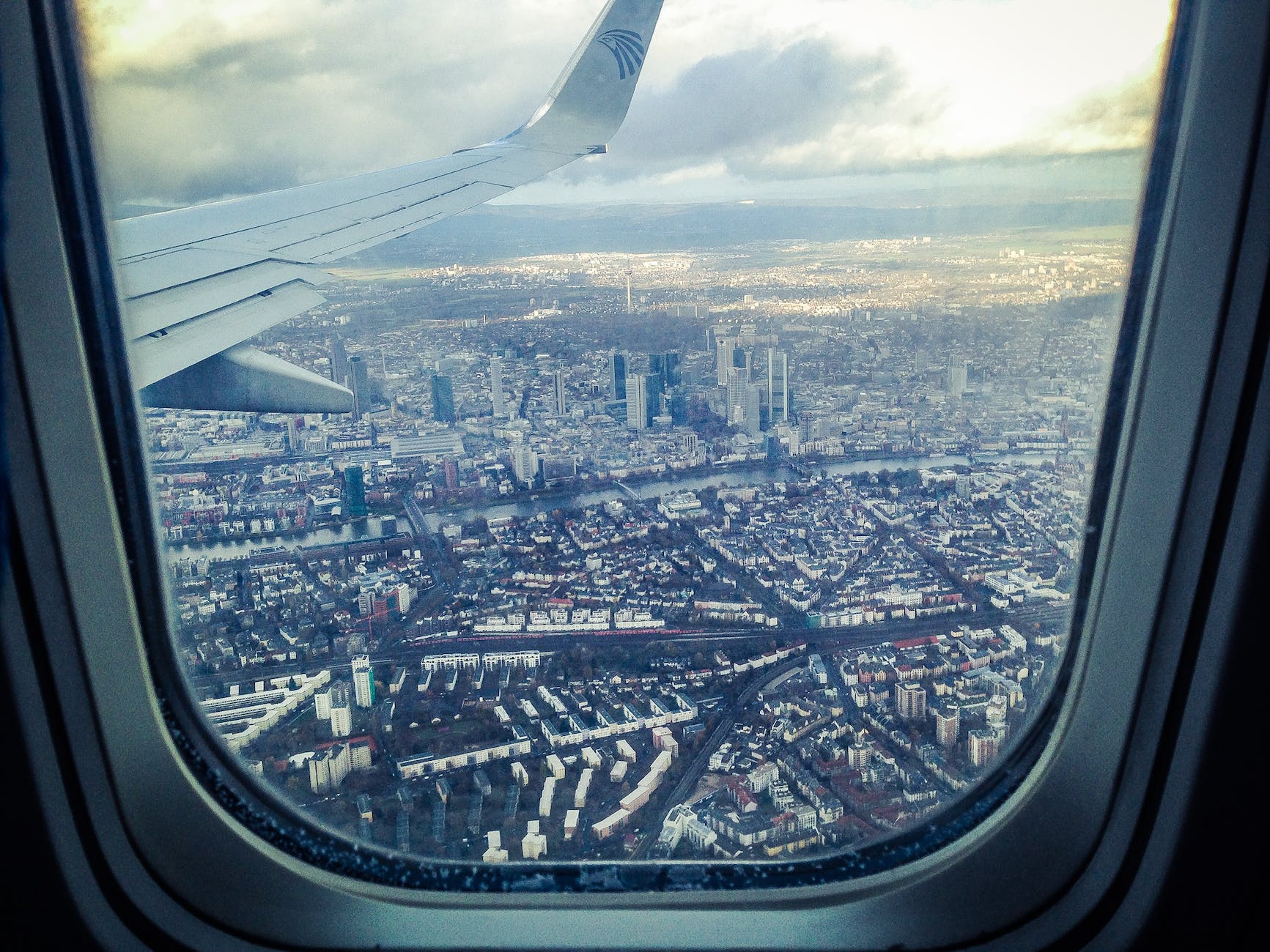 airplane windowpane showing city buildings