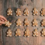 person putting cookie on wooden surface