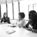 grayscale photography of three woman inside room