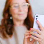 elderly woman messaging on modern smartphone