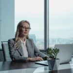 woman in gray blazer sitting by the table