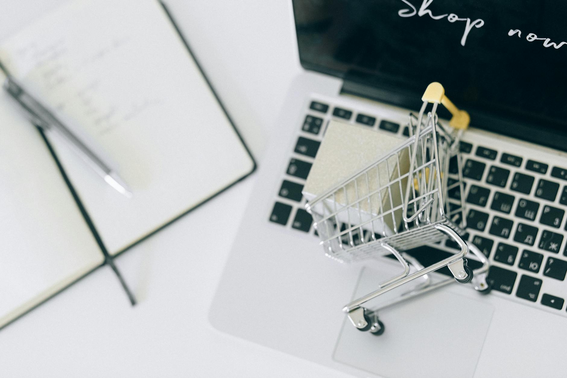 a miniature shopping cart on macbook laptop