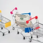 close up photo of money and miniature shopping carts
