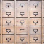 many identical wooden boxes with round handles