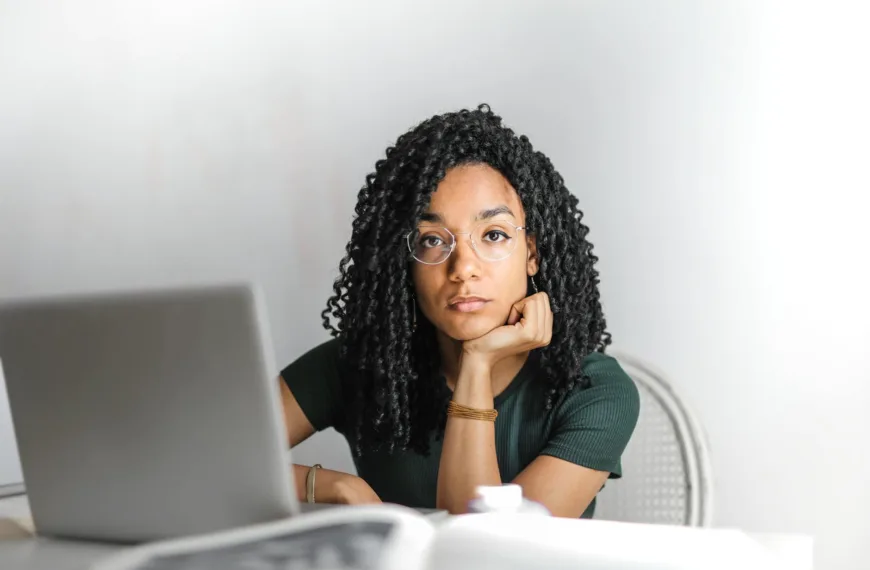 serious ethnic young woman using laptop at home