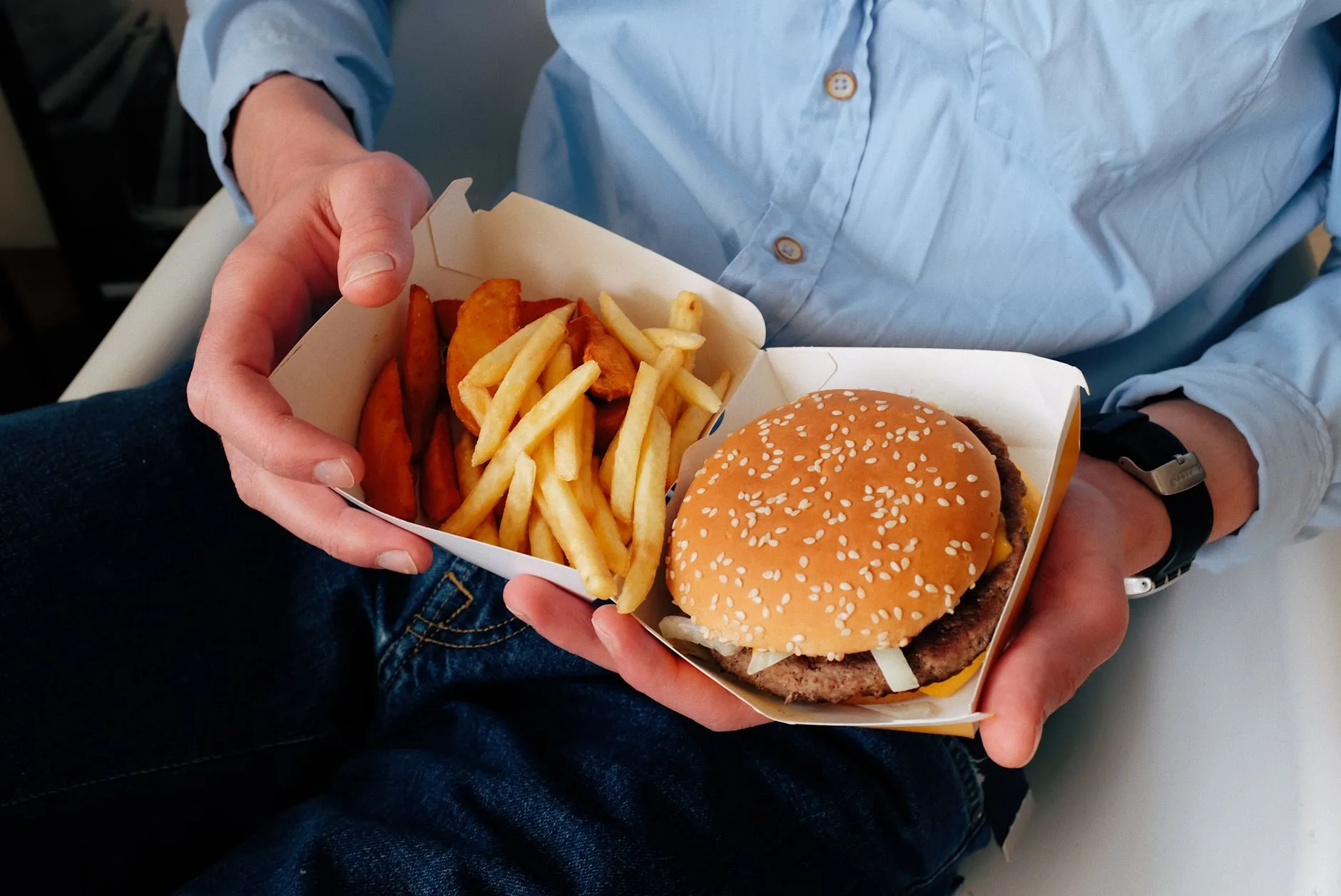 crop man with burger and french fries