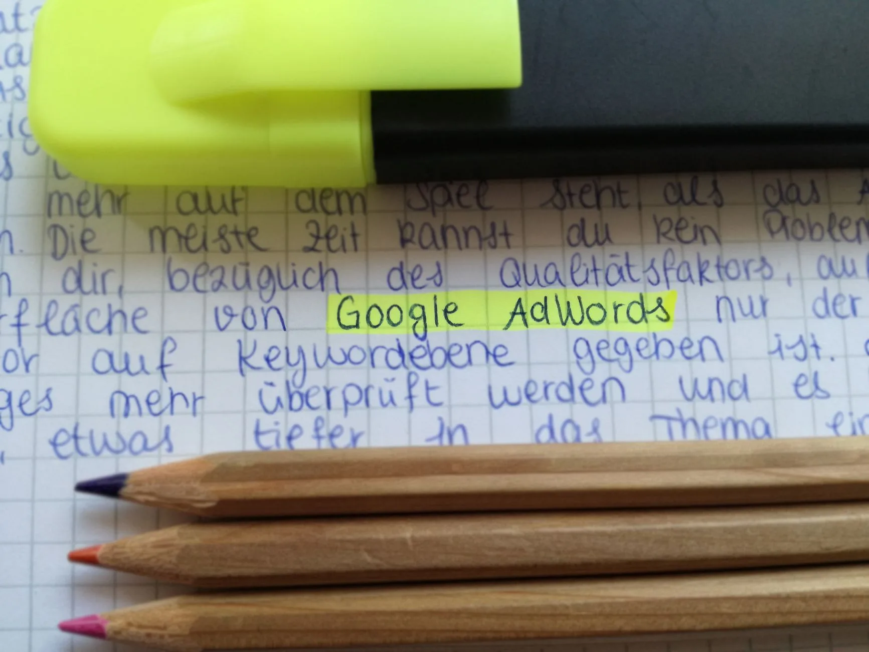 yellow highlighter marker and color pencils on a notebook